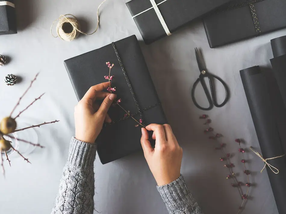 To hender som pakker inn en gave