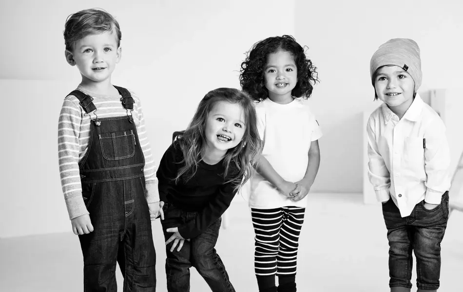 Gjeng med barn smiler til kamera 