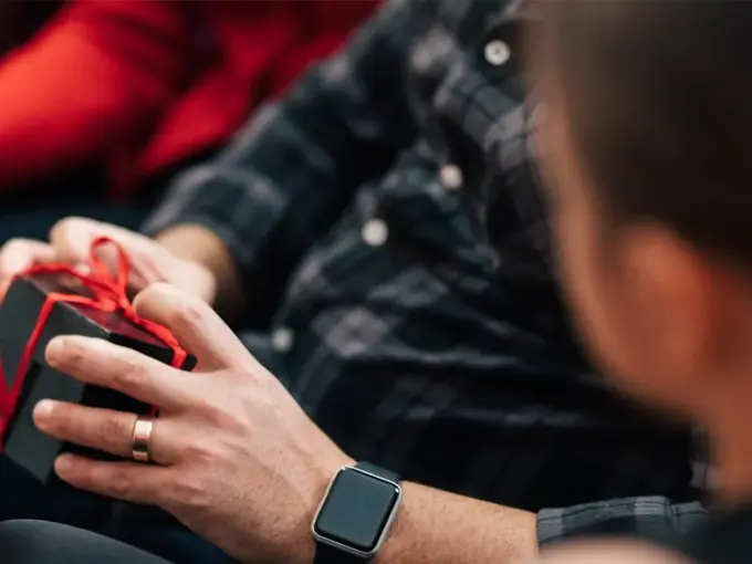 Person holder liten pakke med sløyfe rundt