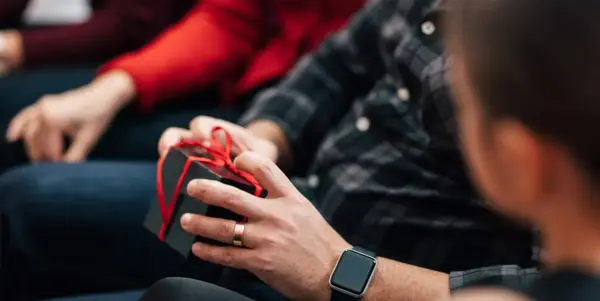 Person holder liten pakke med sløyfe rundt