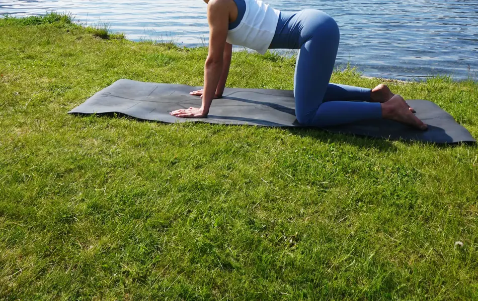 anny johansen viser yogaøvelser foran vakker fjord