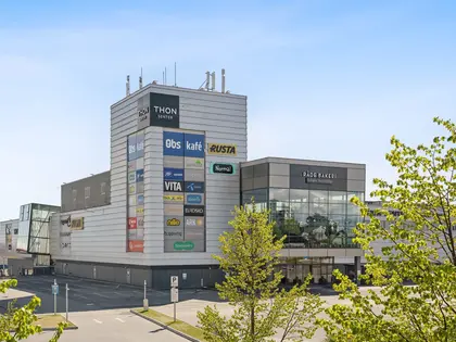 Thon Senter Rygge fasade, med grønne trær i forgrunnen.