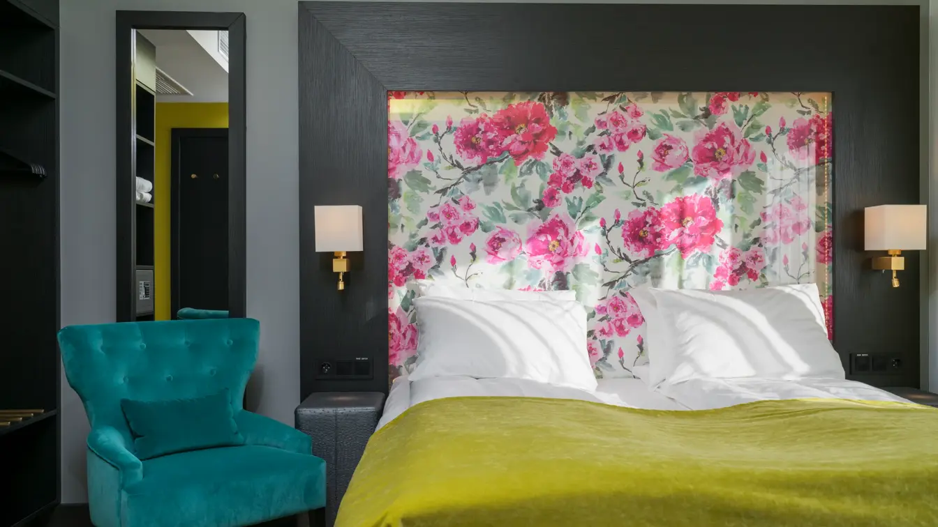 Dobbeltseng med rosetapet og stol i Suite på Thon Hotel Arendal i Arendal sentrum