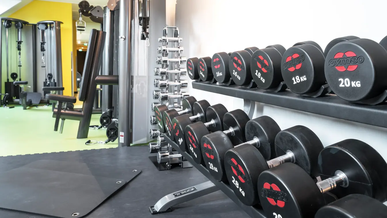 Lyse lokaler med lysegrønne gulv, vekter i treningsrom på Thon Hotel Spectrum i Oslo sentrum