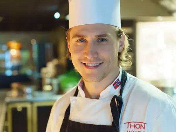 Kjøkkensjef Simon Johannessen smiler på kjøkken på Thon Hotel Bergen Airport