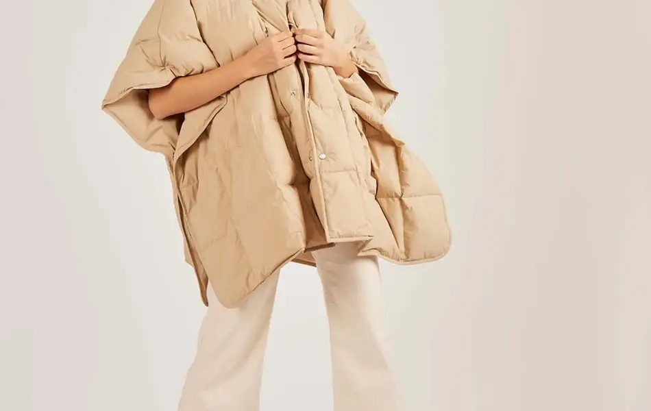 Dame i hvite-/sandfargede klær og chunky skinnsandaler. Illustrasjonsbilde til artikkel om vårmote for sko.