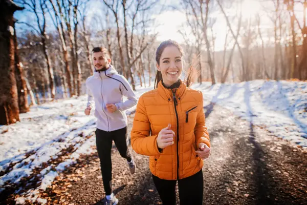 Fitness couple winter morning exercise at snowy mountain.