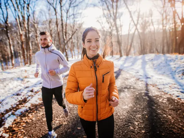 Fitness couple winter morning exercise at snowy mountain.