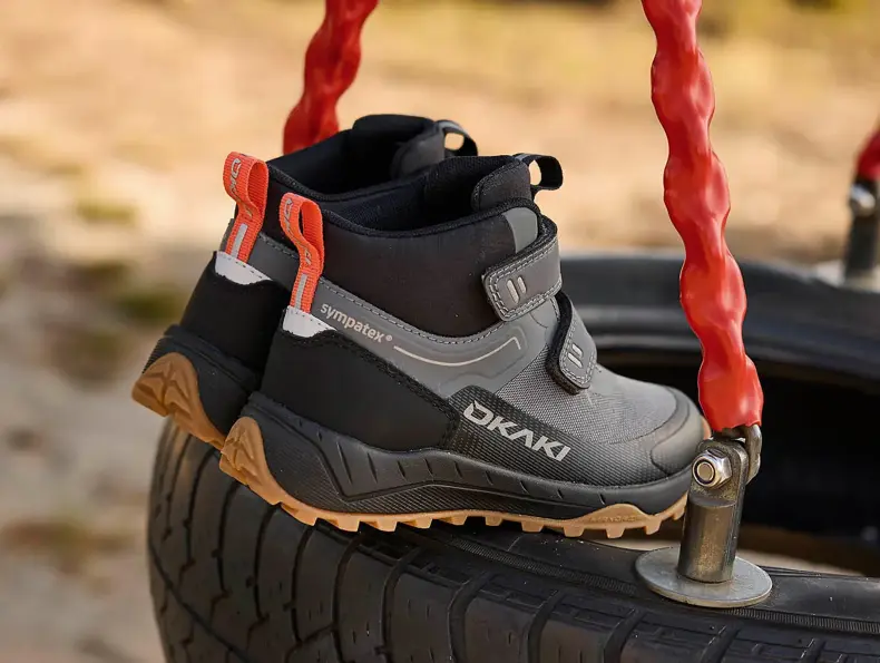 Et par barnesko står på en huske.