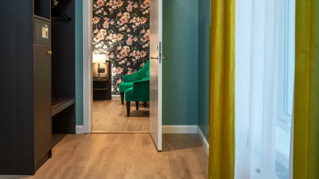 Gang med mørkt klesskap med safe, vindu med gule gardiner og dør inn til soverom.  business rom på Thon Hotel Høyers i Skien.