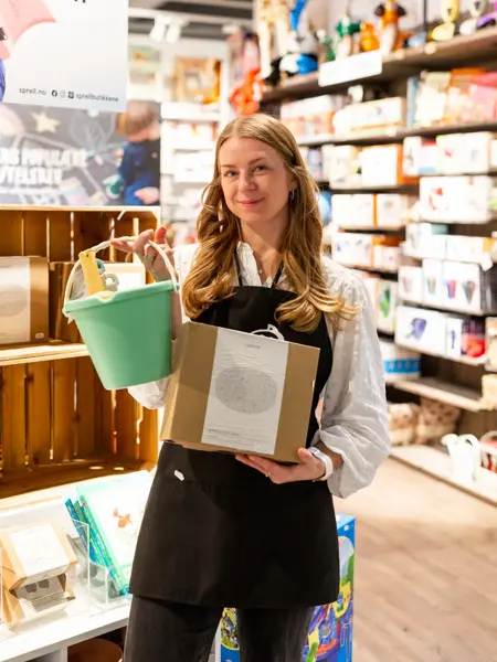 Dame som holder barneleker