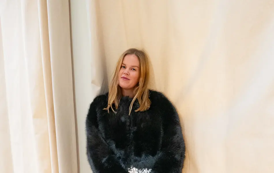 Dame med sort fuskepels, paljettskjørt og sorte pumps.