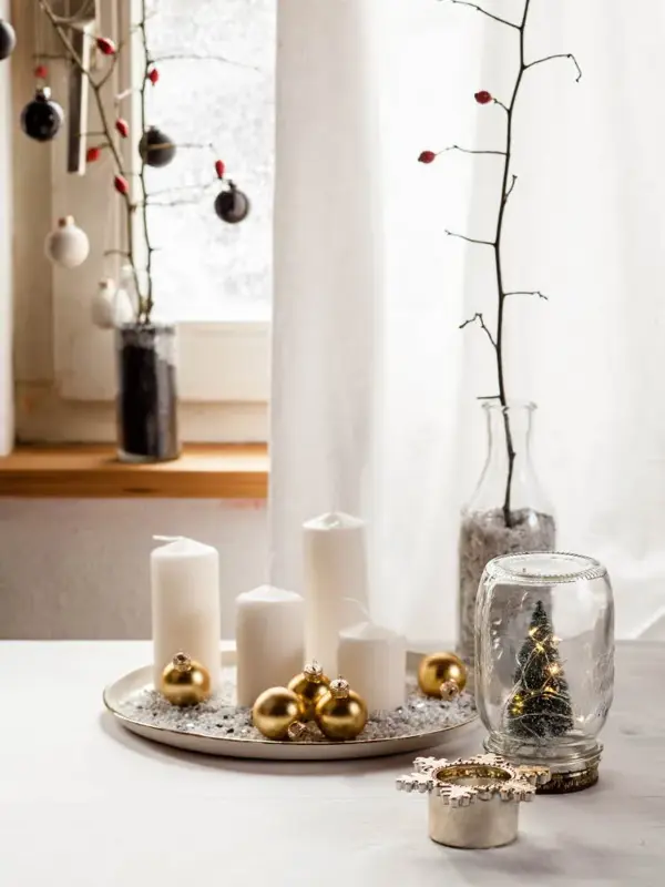 Kubbelys og juledekorasjoner på bord med hvit duk, hvit gardin og vindu i bakgrunnen. Foto til artikkel om julepynt du kan lage selv.