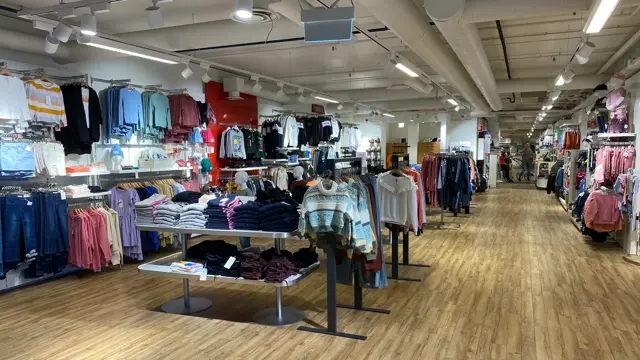innendørs butikk med klær og reoler og lys