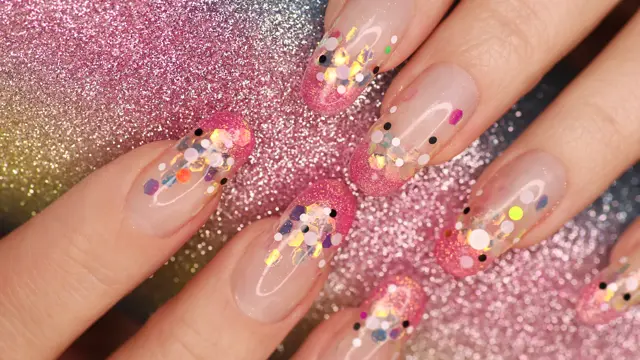 Nærbilde av negler med fargerikt glitter og rosa tupp