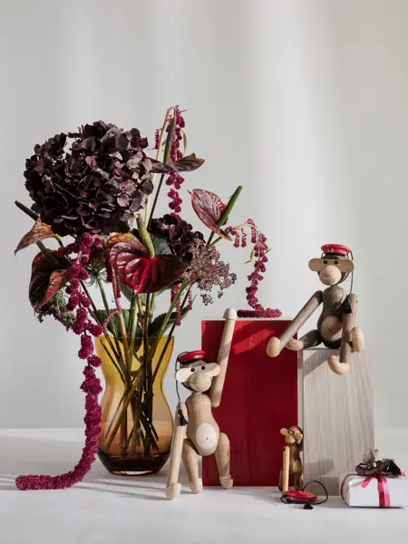 Bord med vase med blomster og Kaj Boyesen apekatter med rød russelue.