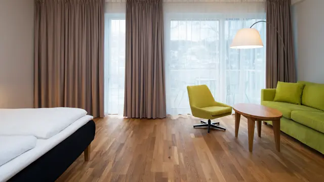 Businessrom med seng, bord og sofa på Thon Hotel Sandven i Nordheimsund