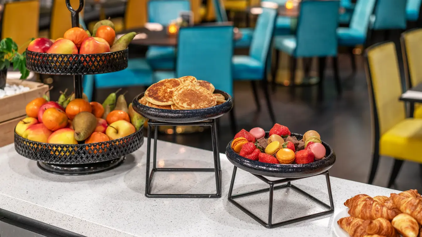 Frokostbuffet med hel frukt på etasjefat, pannekaker, jordbær og crossianter.