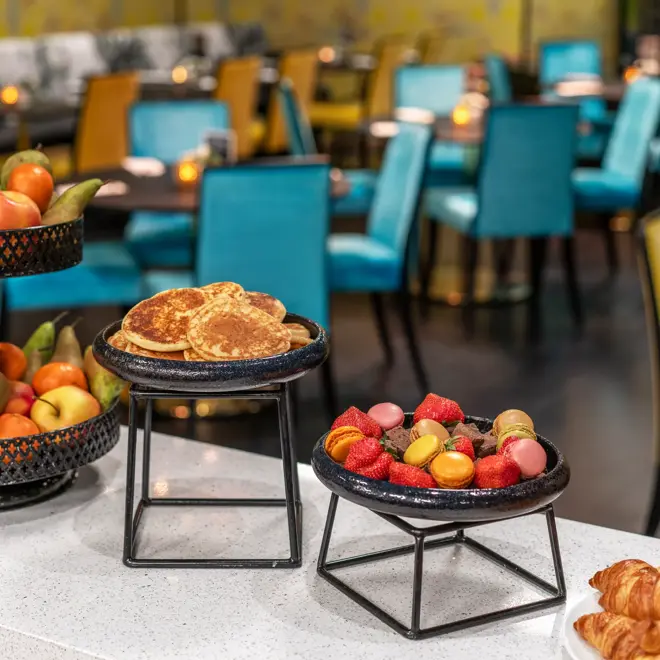 Frokostbuffet med hel frukt på etasjefat, pannekaker, jordbær og crossianter.