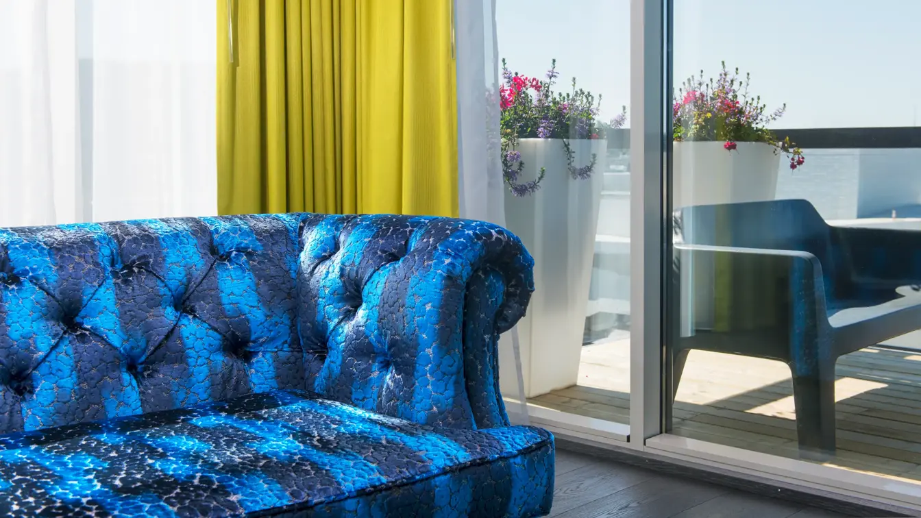 Sofa i suite på Thon Hotel Opera, med utsikt mot balkong. 