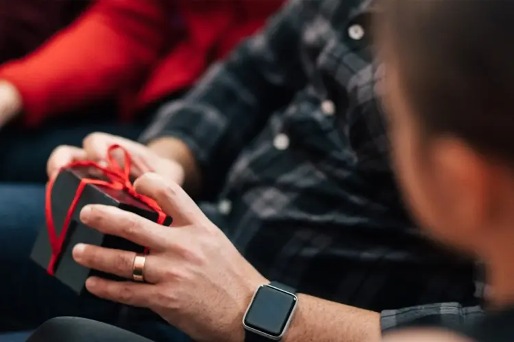 Person holder liten pakke med sløyfe rundt