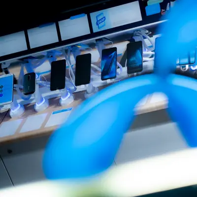 Logo til Telenor, med telefoner i bakgrunnen