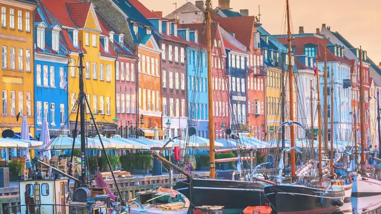 De karakteristiske fargerike byggene i Nyhavn, med vannet og båter foran seg.