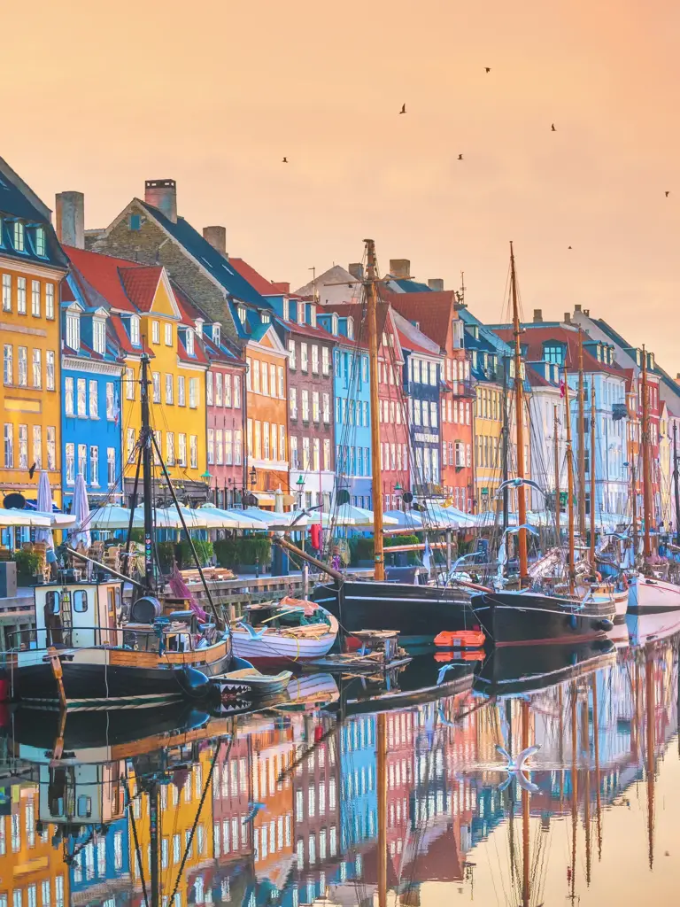 De karakteristiske fargerike byggene i Nyhavn, med vannet og båter foran seg.