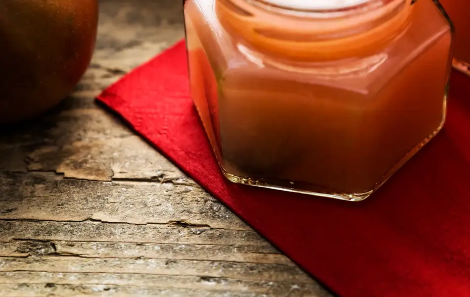 Deutschland, Baden-Württemberg, still life von frischem Apfelmus aus Bioäpfeln. Gefüllte Einmachgläser auf einem Holztisch