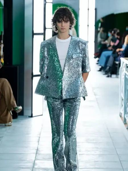 Dame på catwalken med en sølvpaljett dress og hvit t-skjorte inni