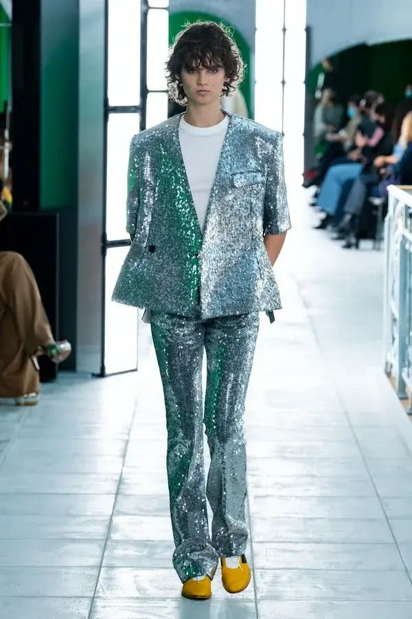 Dame på catwalken med en sølvpaljett dress og hvit t-skjorte inni