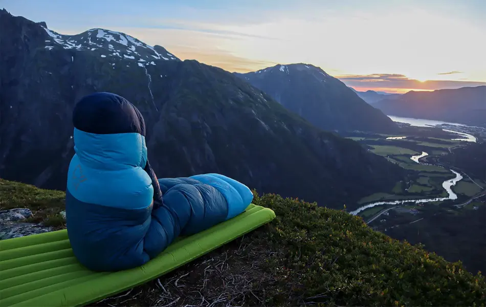 Noen som sitter i en sovepose og ser på utsikten