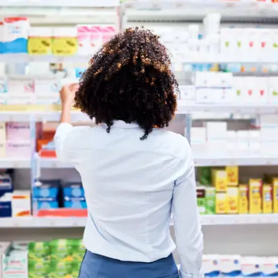 Rearview shot of a young woman looking at products in a pharmacy