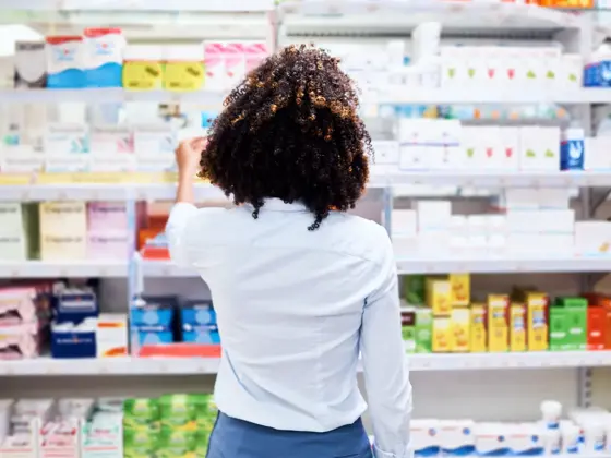 Rearview shot of a young woman looking at products in a pharmacy