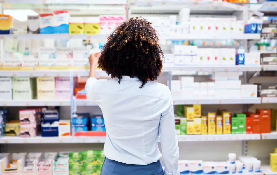 Rearview shot of a young woman looking at products in a pharmacy