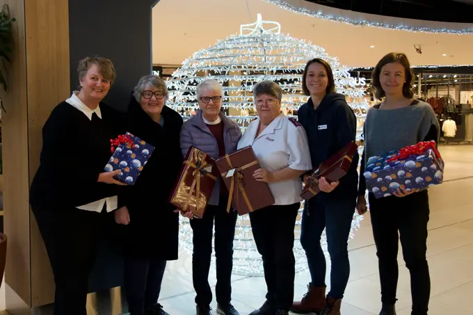 seks personer som holder pakker