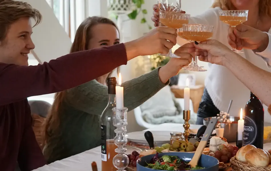 Dekket bord med mat og folk som smiler og deler mat