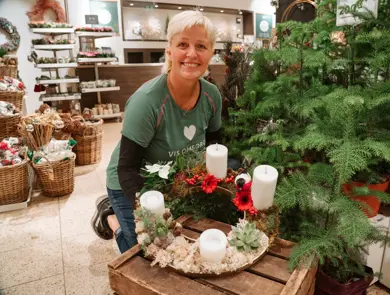 ansatt viser frem hjemmelaget adventsstake