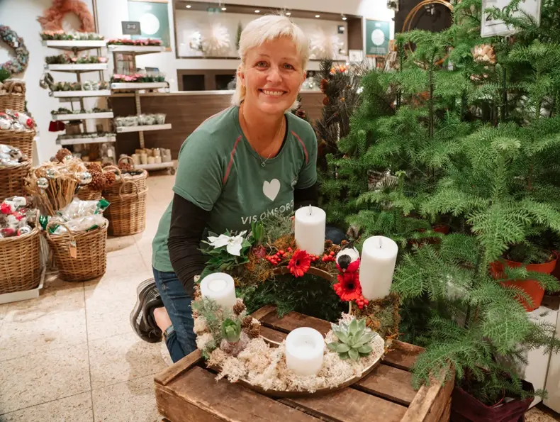 ansatt viser frem hjemmelaget adventsstake