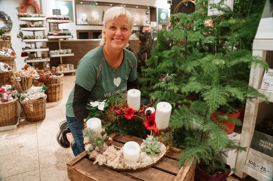 ansatt viser frem hjemmelaget adventsstake