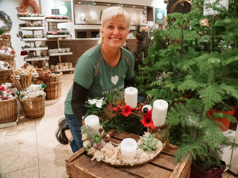 ansatt viser frem hjemmelaget adventsstake