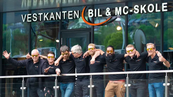 Åtte ansatte står utenfor Vestkanten bil & mc-skole arm i arm