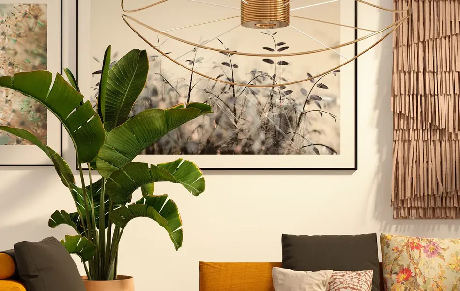 Interiørbilde fra stue med store malerier på veggen og en lav, oransje sofa i sentrum.