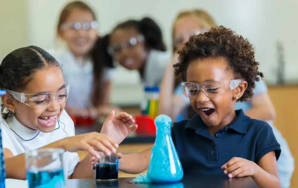 Diverse private school classmates are excited as foam overflows from beaker during chemistry experiment.