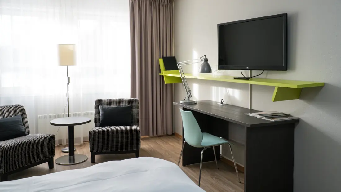 Liten sittegruppe, skrivebord og TV i standard twin rom på Thon Hotel Hallingdal