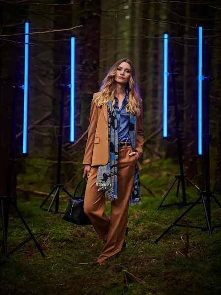 Dame med beige dress i skogen