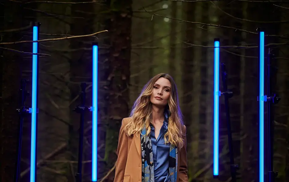 Dame med beige dress i skogen