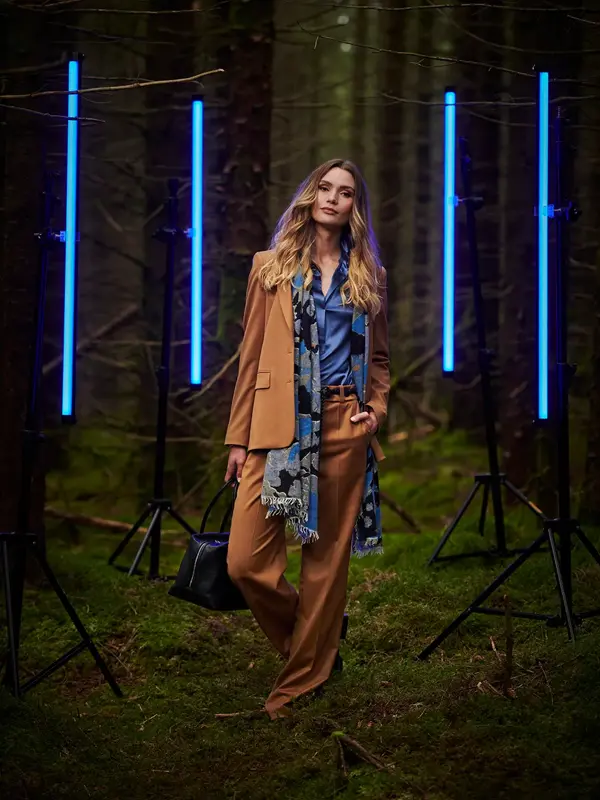 Dame med beige dress i skogen