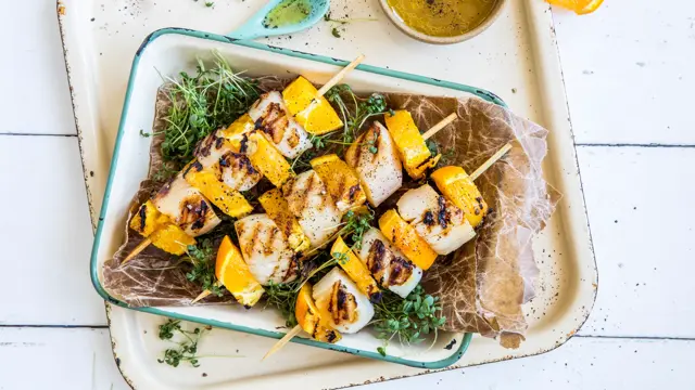 Grillspyd med kamskjell og appelsin i en ildfast form