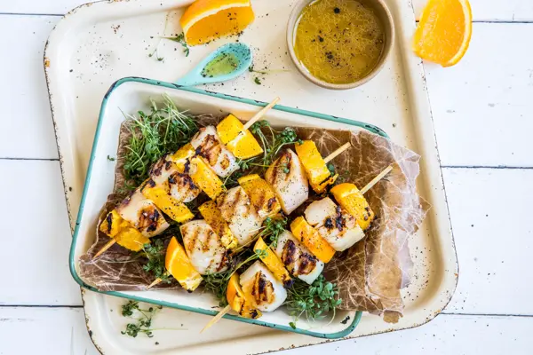 Grillspyd med kamskjell og appelsin i en ildfast form